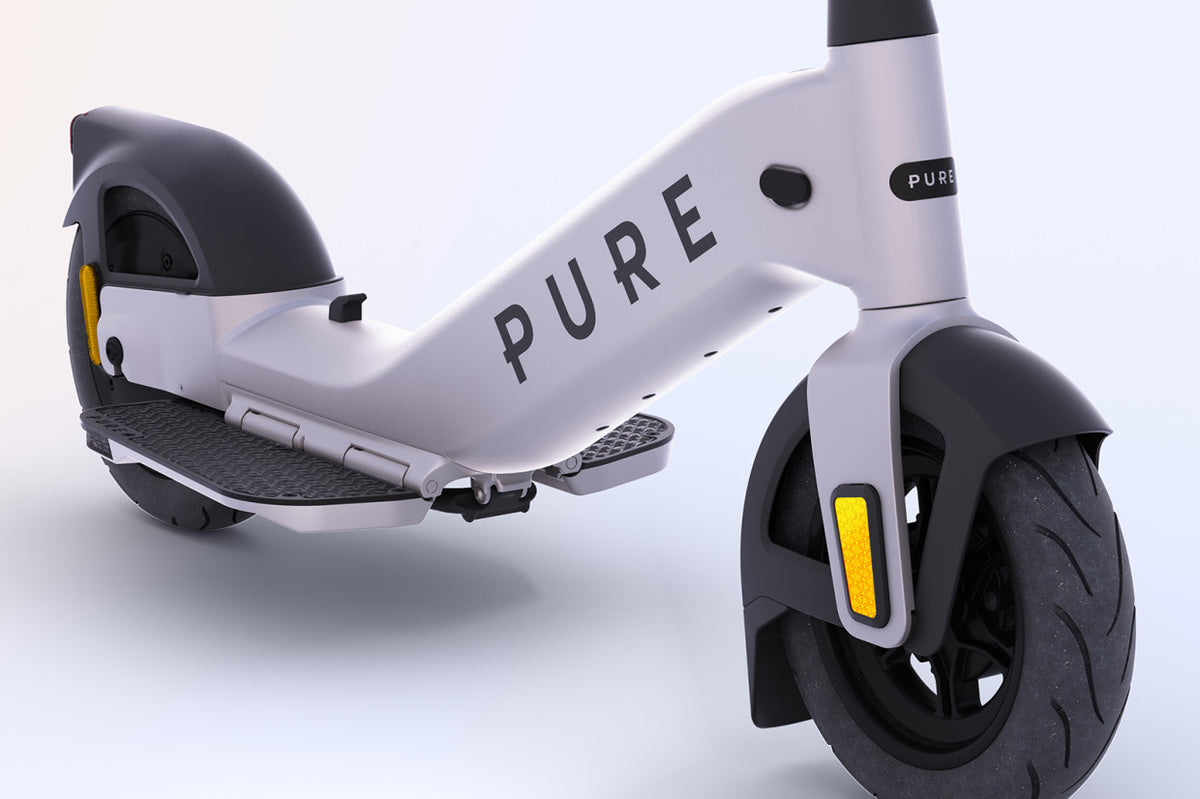 Gros plan du châssis gris clair de la trottinette électrique Pure Advance, avec repose-pied et roue avant