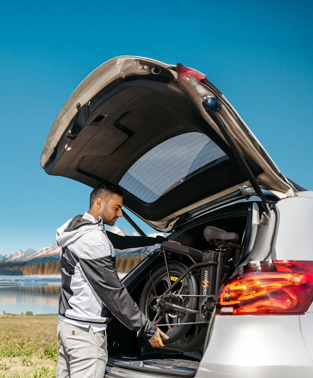 Vélo électrique pliant HillMiles MilePort 1 chargé dans le coffre d'une voiture, vue latérale